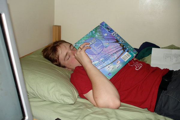 student asleep with text book on face