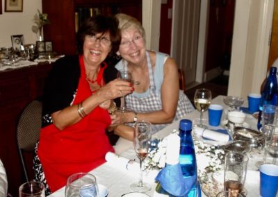 Two women laughing at dining table